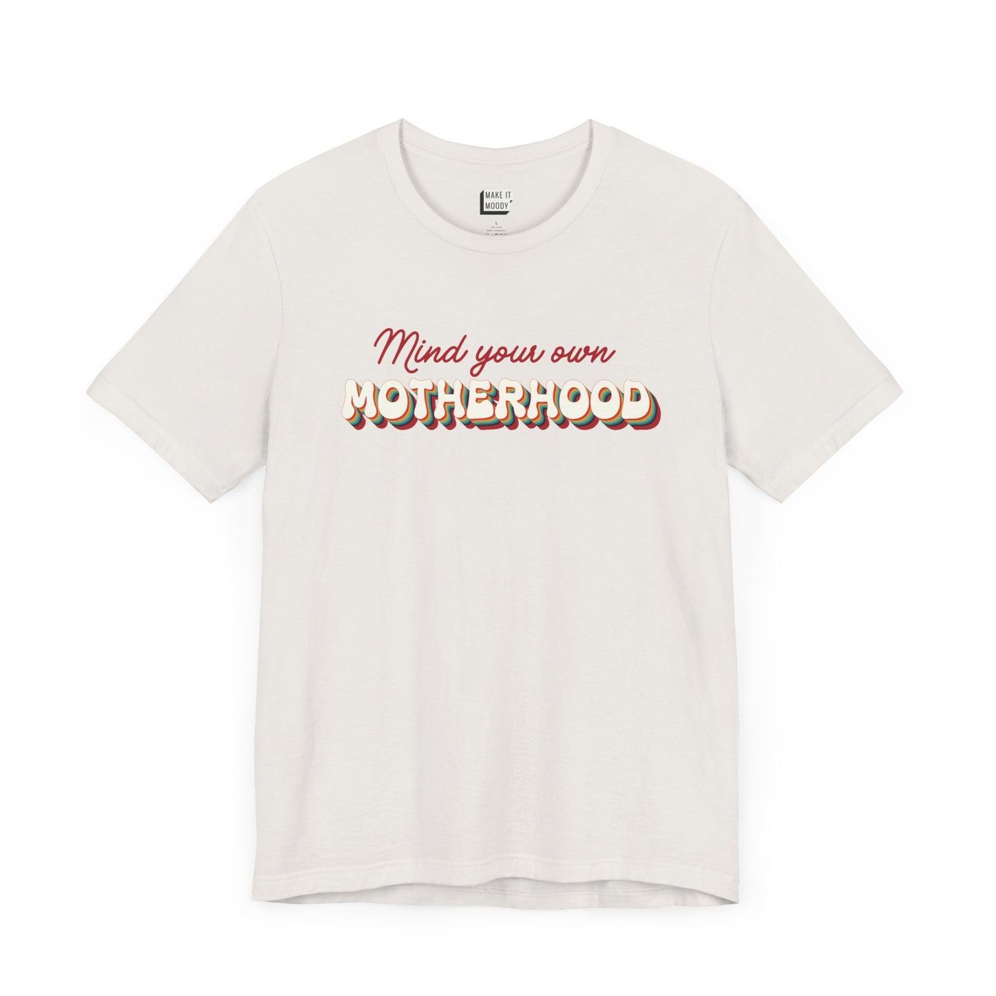 Off-white mom t-shirt featuring the text Mind your own MOTHERHOOD in red and rainbow-colored 3D-style retro letters.