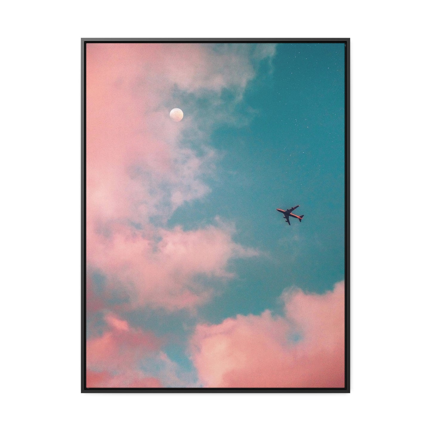 A "Cotton Candy Skies" Airplane - Themed Framed Gallery Wrapped Canvas in black, featuring an airplane gliding against a backdrop of pink clouds, a blue sky, and the moon.