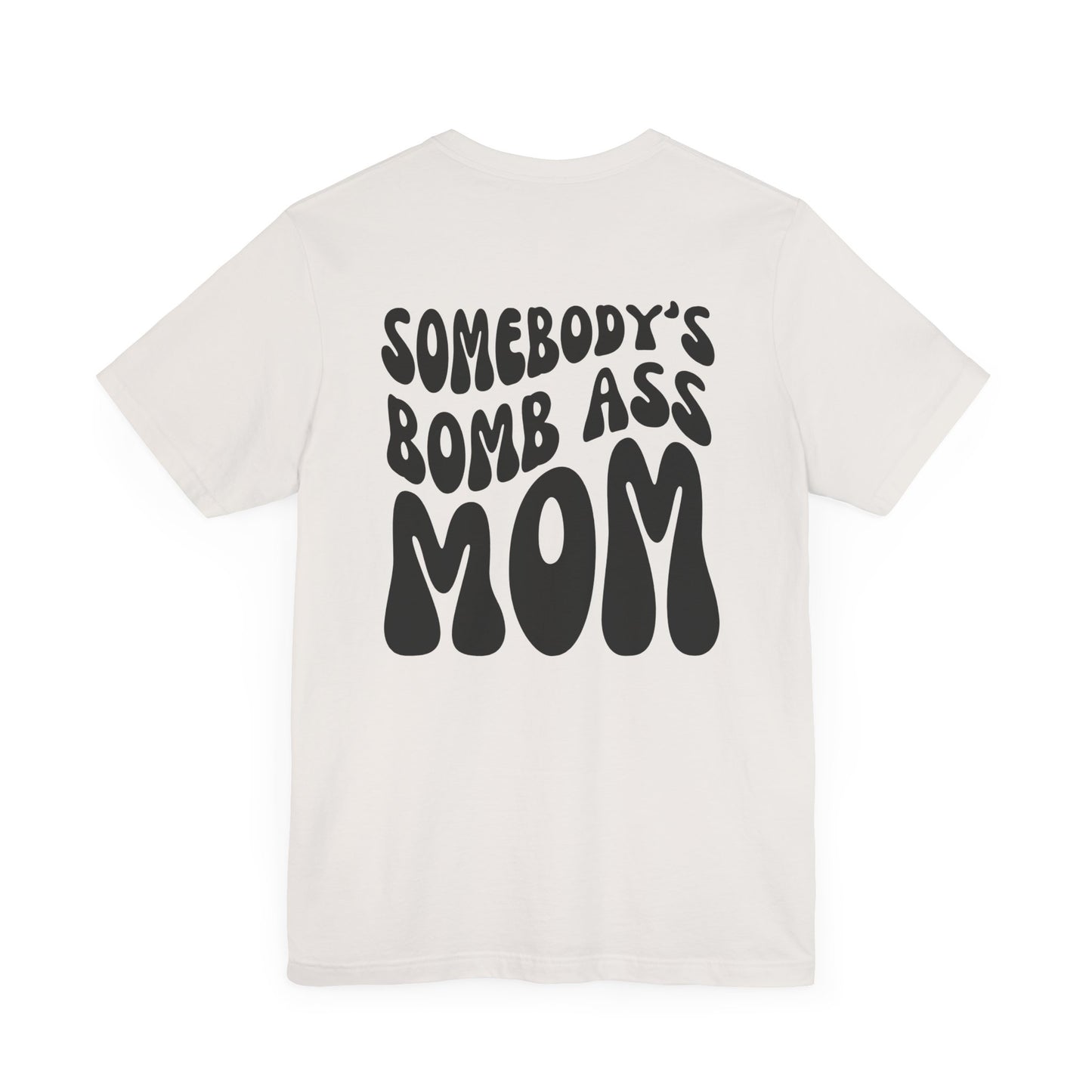 White mom t-shirt featuring bold black retro text on the back that reads SOMEBODY'S BOMB ASS MOM.