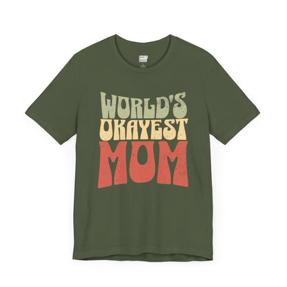 Army green mom t-shirt with the text WORLD'S OKAYEST MOM in large retro-style yellow and orange letters on the front.