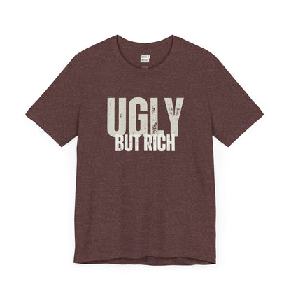 funny t shirt in maroon that says UGLY BUT RICH in bold white lettering