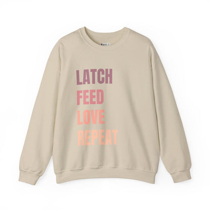 Sand colored breastfeeding sweatshirt that says LATCH FEED LOVE REPEAT in bold pink gradient font.