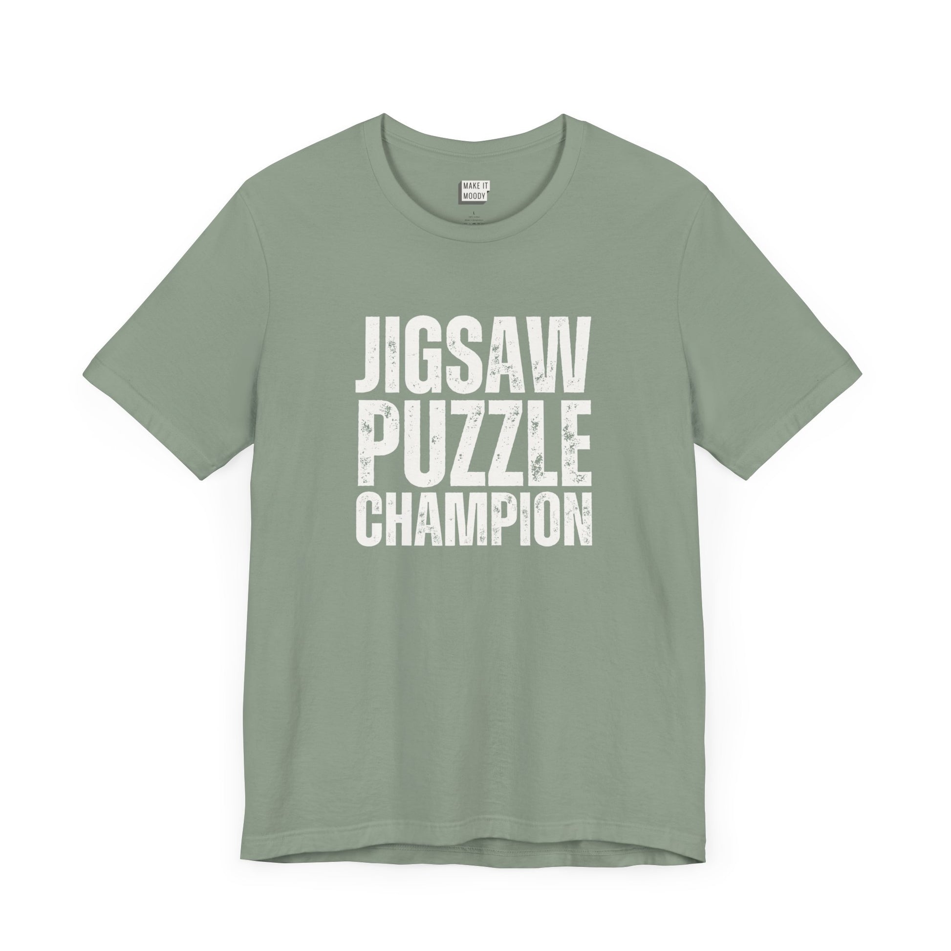 funny graphic t shirt in sage green that says JIGSAW PUZZLE CHAMPION in bold white lettering