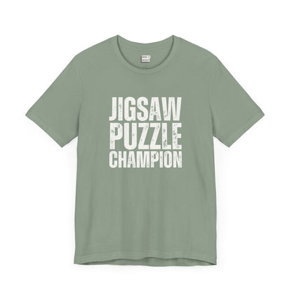 funny graphic t shirt in sage green that says JIGSAW PUZZLE CHAMPION in bold white lettering