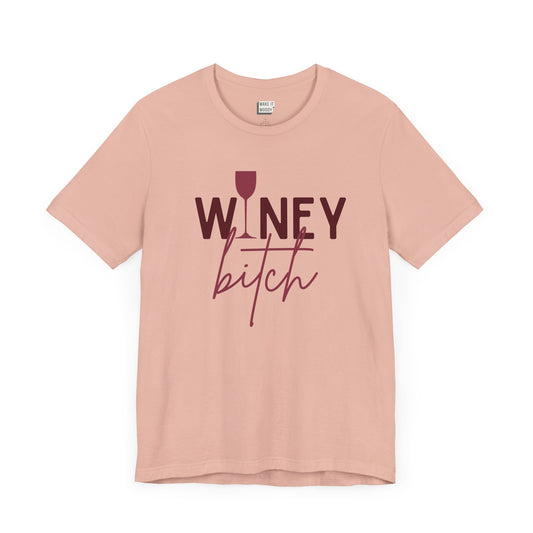 peach colored drinking t-shirt that says WINEY BITCH on the front. There is a graphic of a wine glass in place of the I in the word winey.