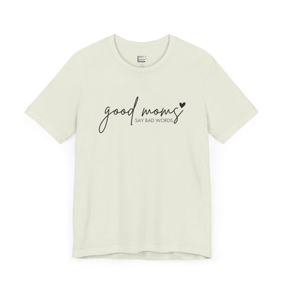 Mom Tee in light green, featuring black cursive and print text with the words good moms SAY BAD WORDS, accented by a small heart.