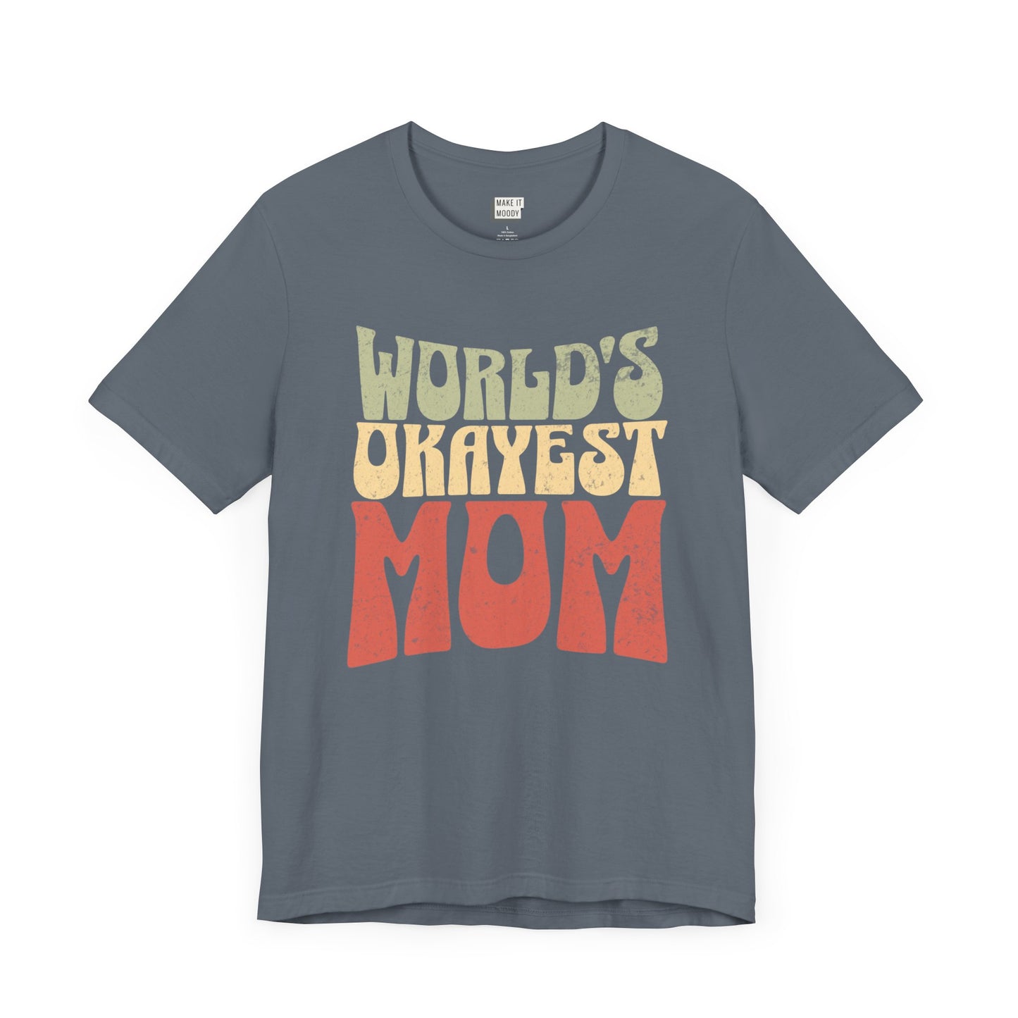 Slate blue mom t-shirt with the text WORLD'S OKAYEST MOM in large retro-style yellow and orange letters on the front.