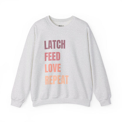 Ash colored breastfeeding sweatshirt that says LATCH FEED LOVE REPEAT in bold pink gradient font.