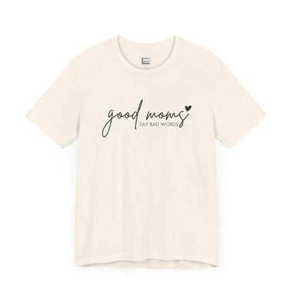 Mom Tee in off-white, featuring black cursive and print text with the words good moms SAY BAD WORDS, accented by a small heart.