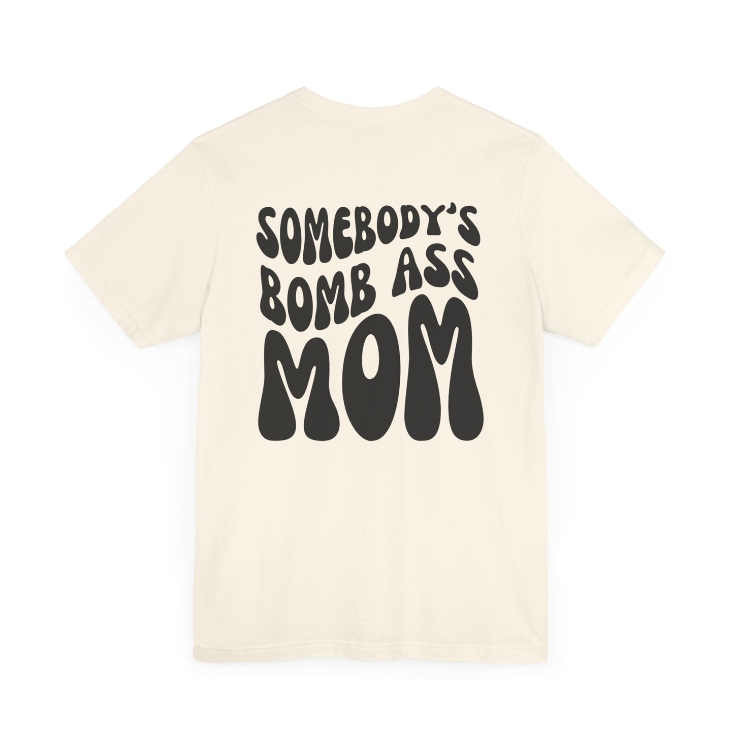 Off-white mom t-shirt featuring bold black retro text on the back that reads SOMEBODY'S BOMB ASS MOM.