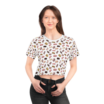 Woman in black jeans and a Boob Pattern Cropped Breastfeeding Tee, standing with hands in pockets, smiling against a plain white background.