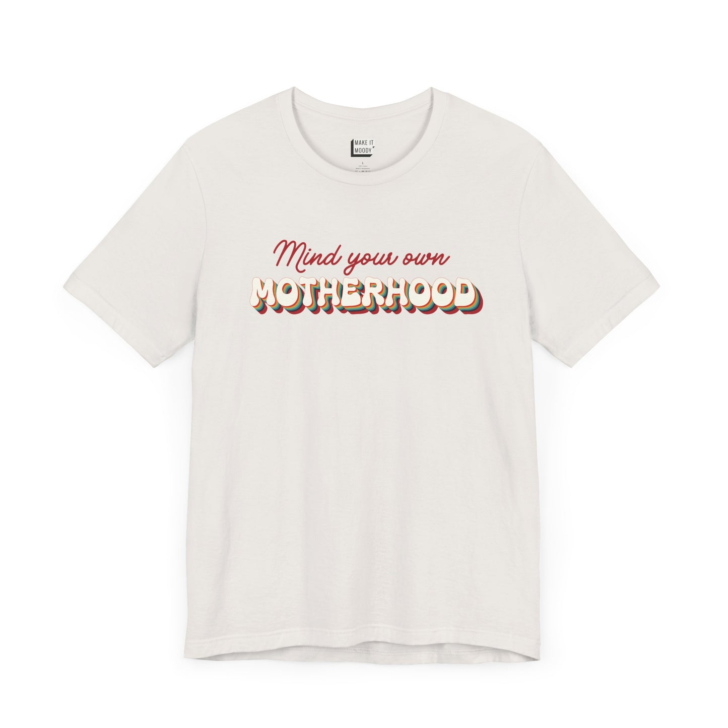 Off-white mom t-shirt featuring the text Mind your own MOTHERHOOD in red and rainbow-colored 3D-style retro letters.