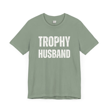 funny t shirt for men in sage green that says TROPHY HUSBAND in bold white lettering