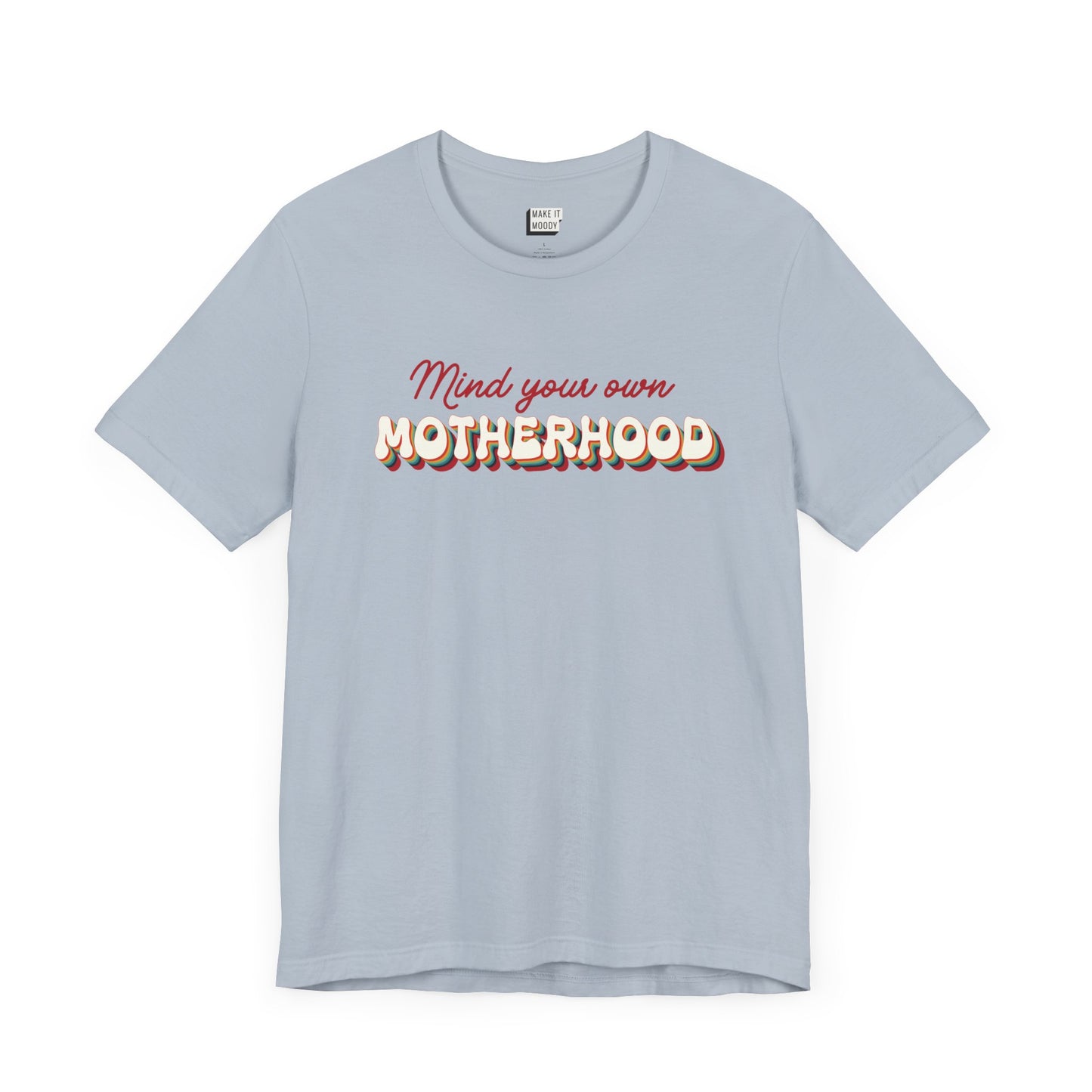 Light blue mom t-shirt featuring the text Mind your own MOTHERHOOD in red and rainbow-colored 3D-style retro letters.