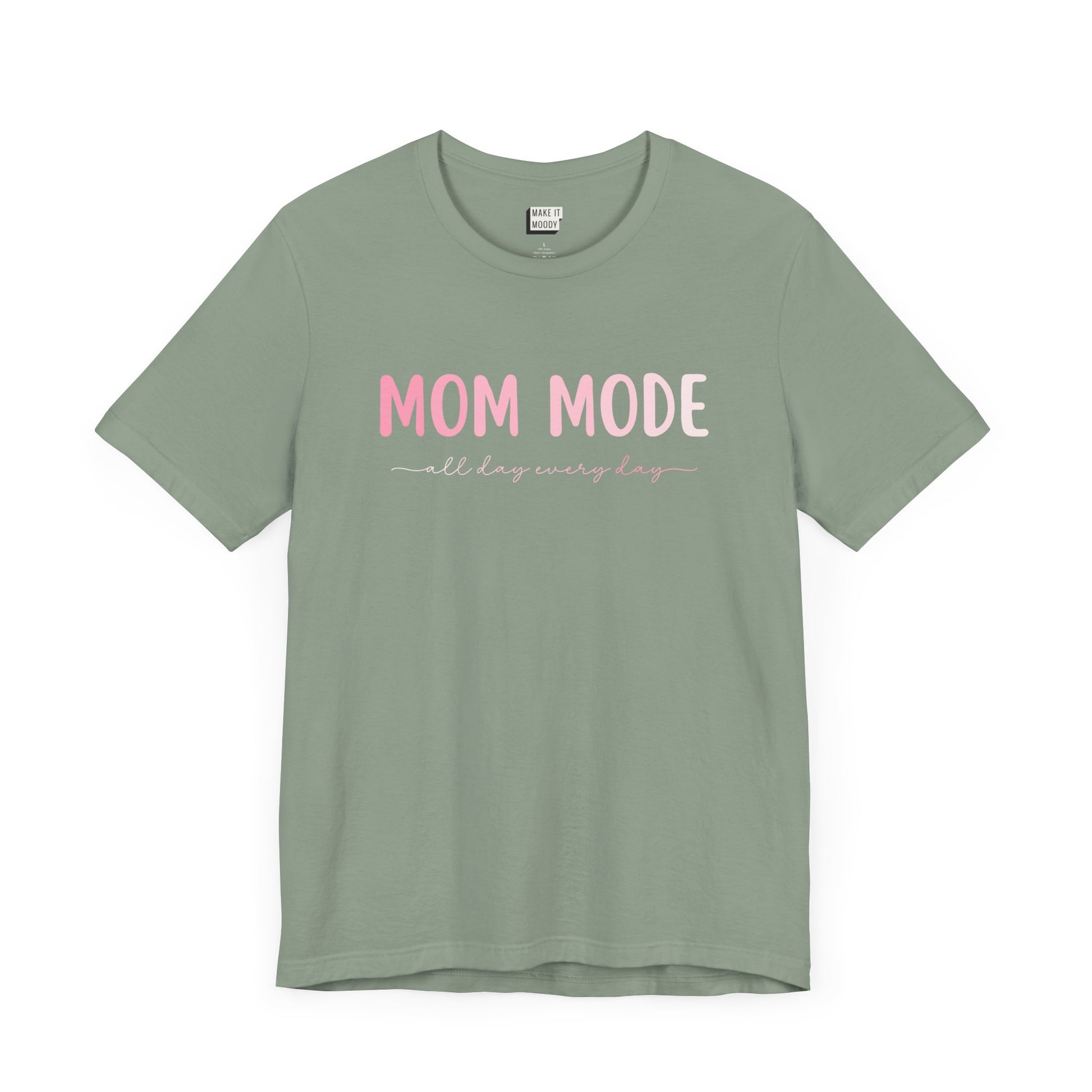 Sage green-colored mom t-shirt with the text MOM MODE all day every day in pink and white font.