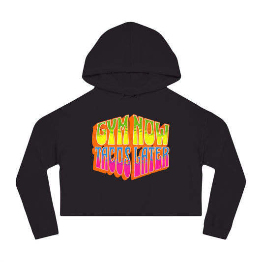 Black cropped women's gym hoodie that says GYM NOW, TACOS LATER in bold multicolor lettering.