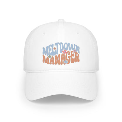 White "Meltdown Manager" Mom Hat adorned with vibrant text and small flower designs around the letters.