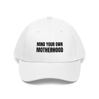 Mind Your Own Motherhood Hat, featuring the phrase "MIND YOUR OWN MOTHERHOOD" boldly printed in black on its white front.