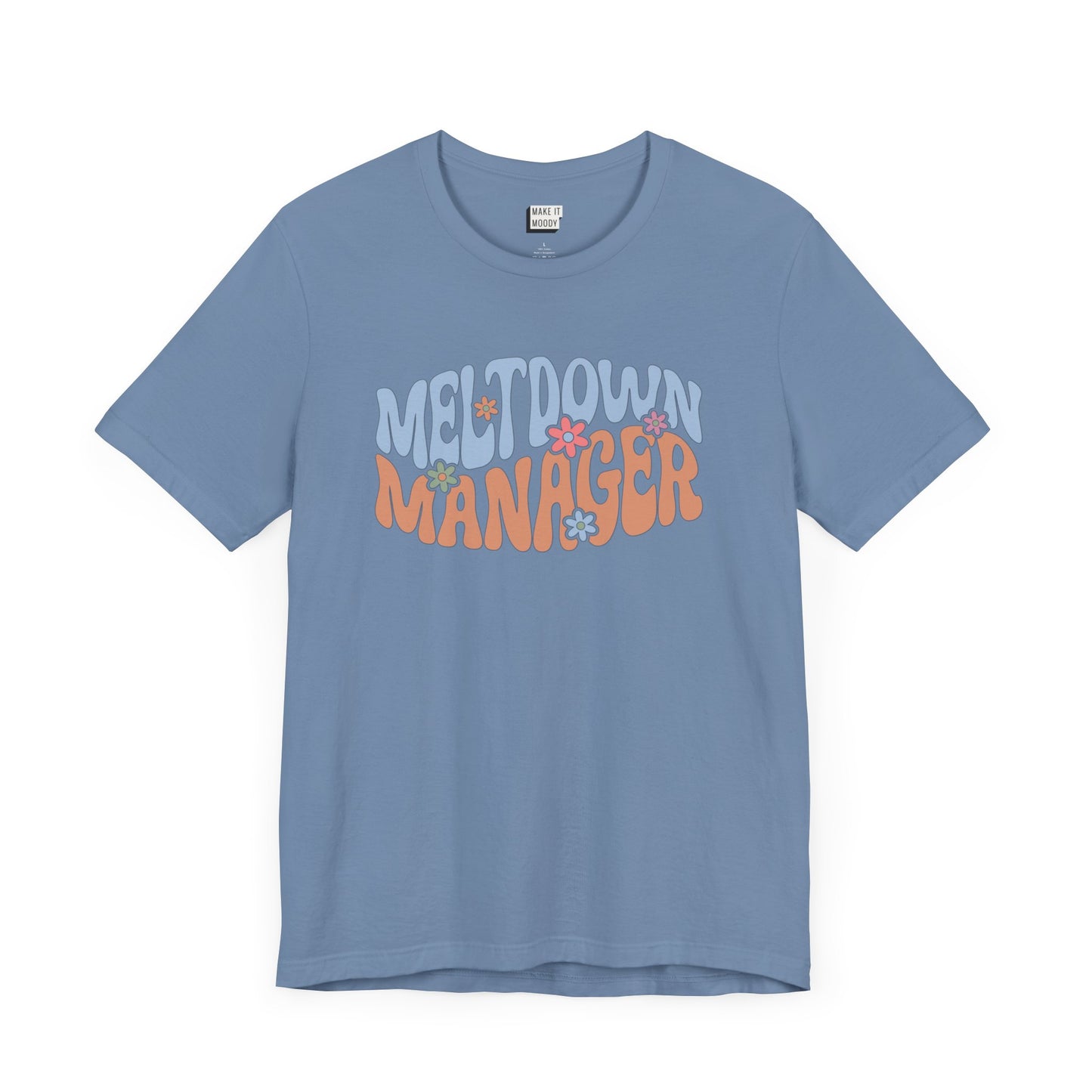 Steel blue colored mom t-shirt featuring the words MELTDOWN MANAGER in a colorful retro-style font with retro flower designs.