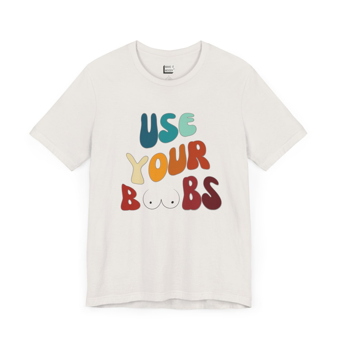 Vintage white Breastfeeding T-shirt that says USE YOUR BOOBS in multicolor retro lettering with a minimalistic breast graphic in place of the double O in the word BOOBS.
