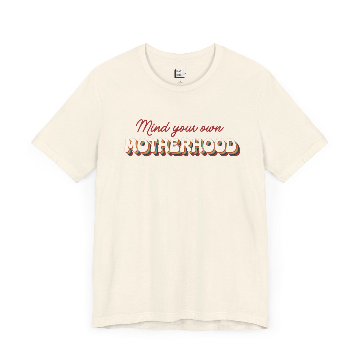 Off-white mom t-shirt featuring the text Mind your own MOTHERHOOD in red and rainbow-colored 3D-style retro letters.