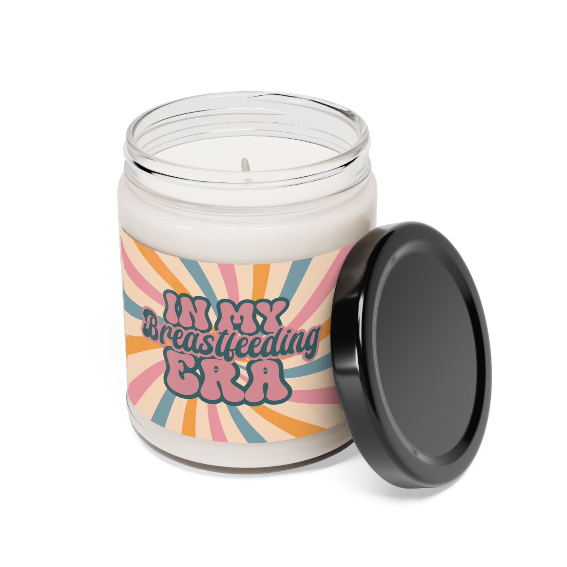 The "In My Breastfeeding Era" Scented Soy Candle, 9oz, is a white candle in a glass jar with a black lid and a colorful label. Made from natural soy wax and aromatic scents, it creates a soothing atmosphere for new mothers.