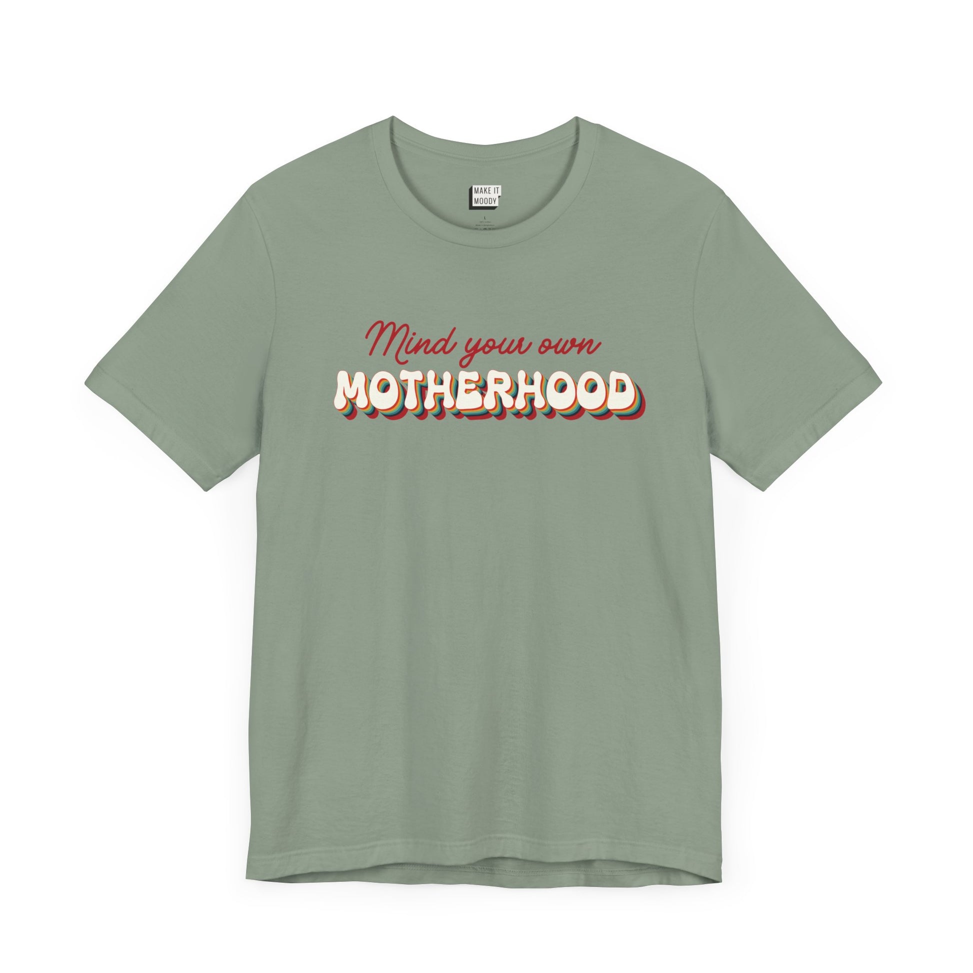 Sage green mom t-shirt featuring the text Mind your own MOTHERHOOD in red and rainbow-colored 3D-style retro letters.