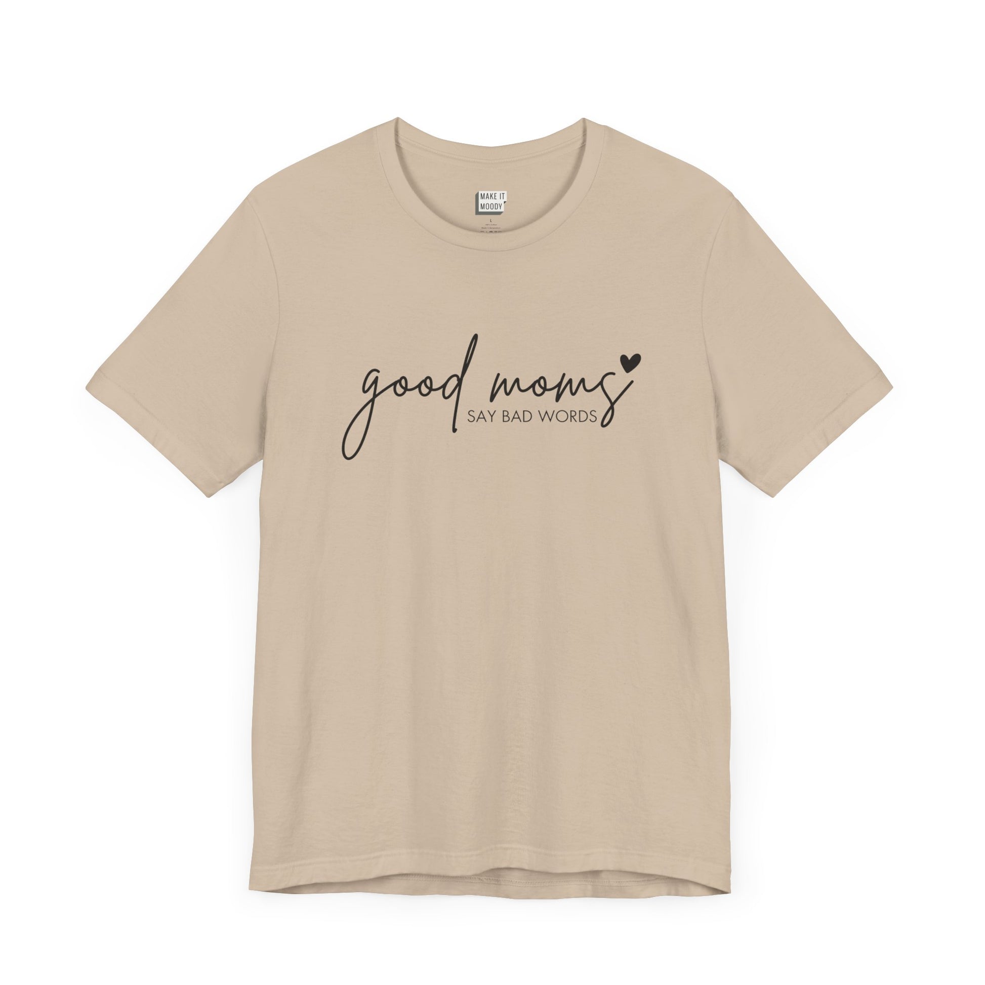 Mom Tee in tan, featuring black cursive and print text with the words good moms SAY BAD WORDS, accented by a small heart.