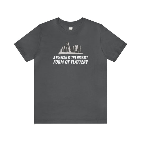 Dark gray "A Plateau Is the Highest Form of Flattery" tee with white text and plateau graphic.