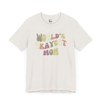 Vintage white mom t-shirt with colorful, playful text that reads WORLD'S OKAYEST MOM.
