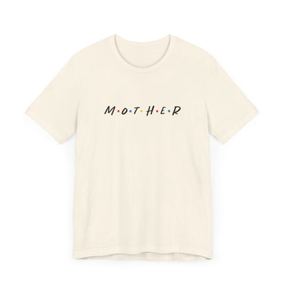 Mom t-shirt in off-white with MOTHER displayed in bold black letters, accented by colored dots between each letter. The design is reminiscent of the logo from the tv show called Friends.